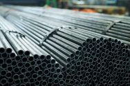 Industrial background of  black metal pipes ready for shipping in production workshop of metalworking plant, copy space